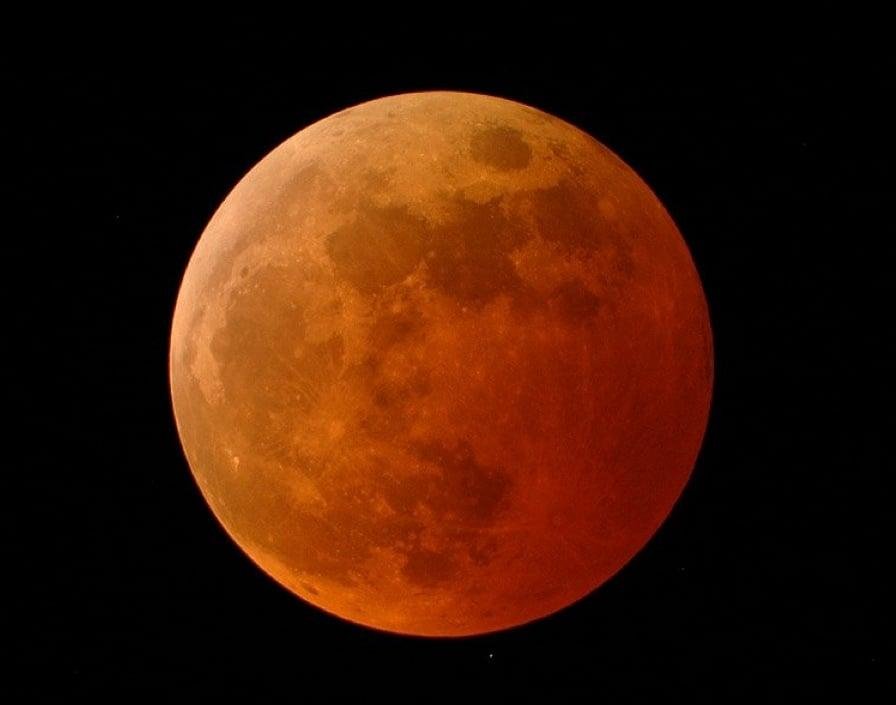 A blood moon during a total lunar eclipse, showcasing a reddish or coppery hue.