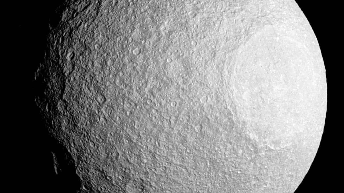 Saturn’s moon Tethys, depicted in the image, is known for having the lowest density of any moon in the solar system, primarily composed of water ice.