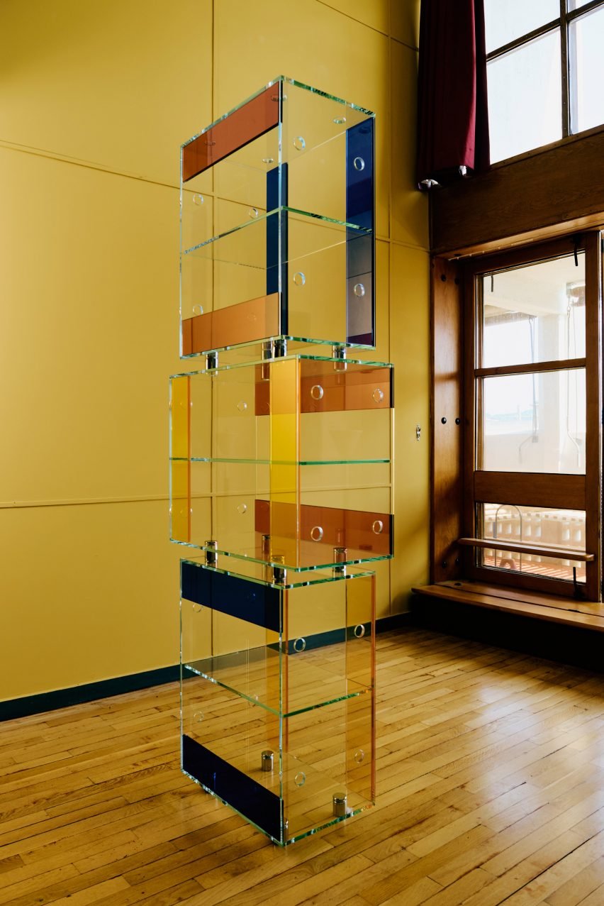 Clear glass shelves made with standardized boxes used to create versatile storage solutions in the exhibition.