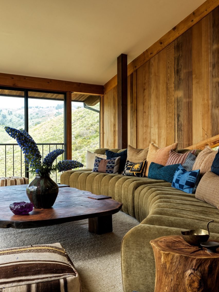 The living room showcases a custom curved sofa designed to enhance the view of the canyon.