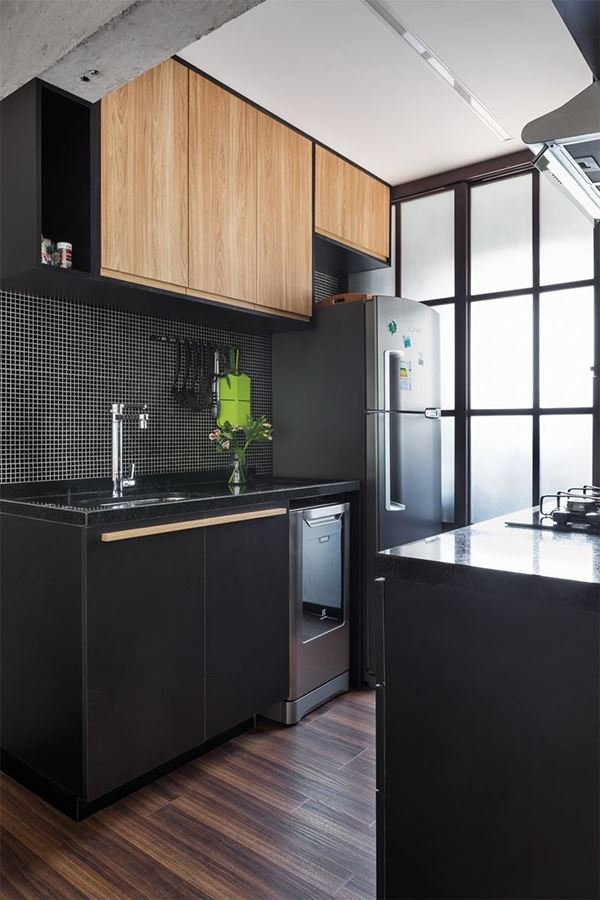 A modern kitchen design with black cabinets and wooden accents