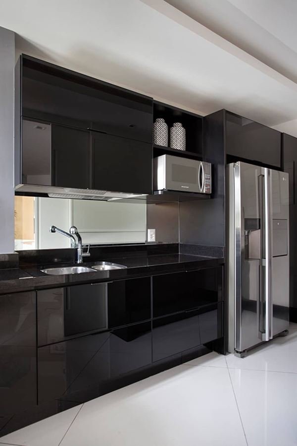 A kitchen with stainless steel appliances against black cabinetry