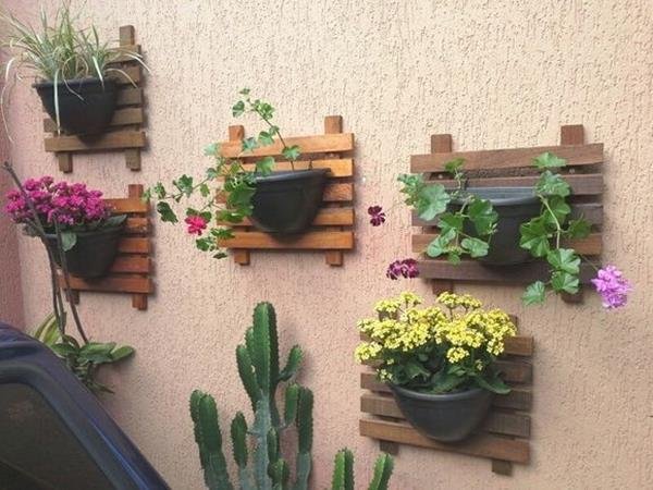 The arrangement includes wooden elements, utilizing pallets as wall supports for plants.