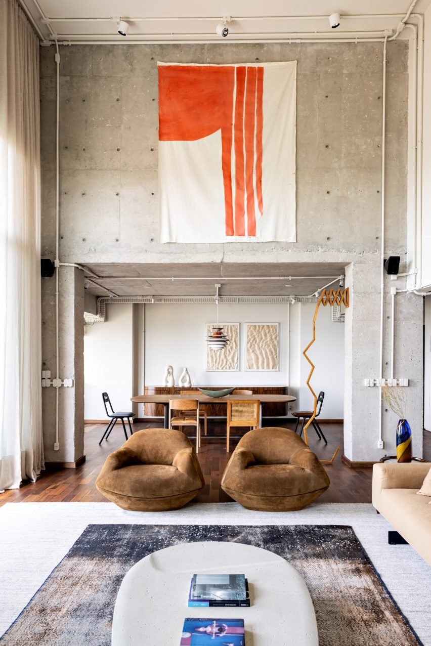 A cozy Gale Apartment featuring earthy-toned lounge chairs and concrete design.