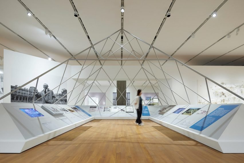 The iconic mockup of the Musée du Louvre pyramid at the exhibition's center.