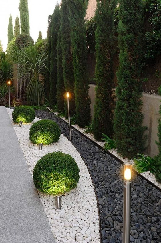 In this garden, black and white gravel stones were used, highlighted by the lighting.