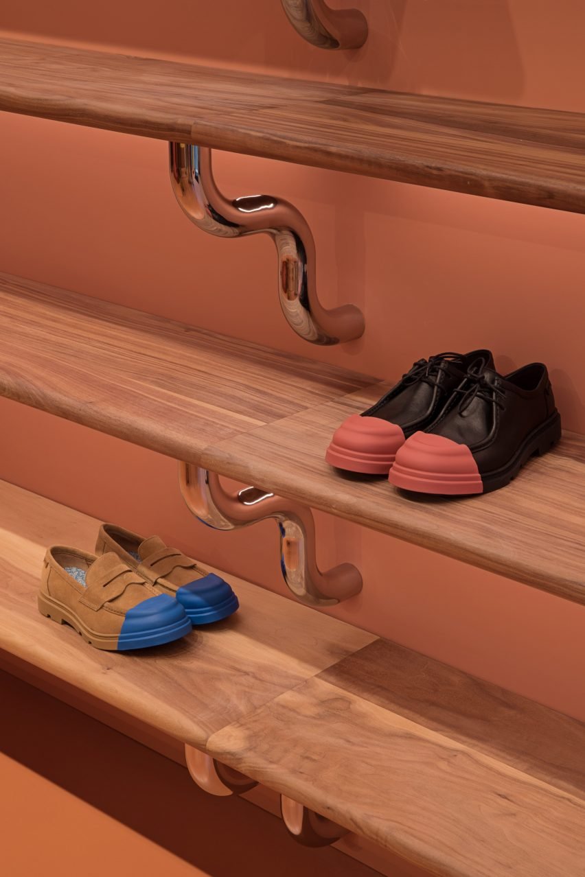 Visuals of the yellow recycled plastic shelving combined with walnut stools, highlighting design intricacies.