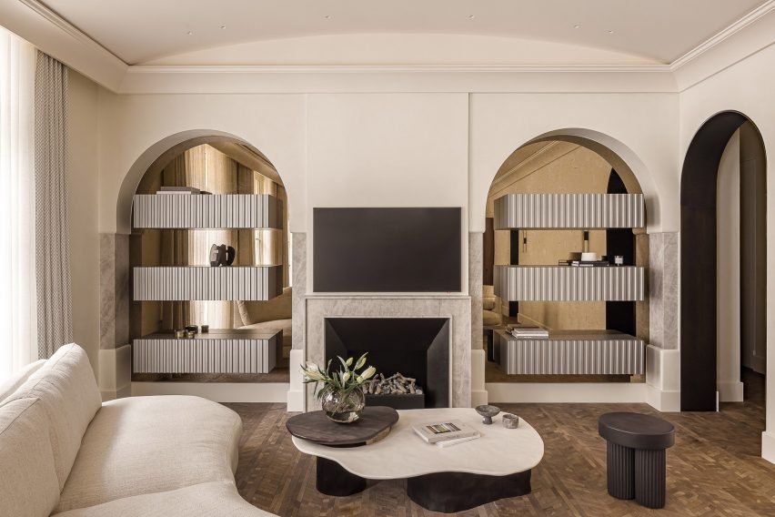 This living room showcases parquet floors, bronze mirrors, and elegant marble accents.