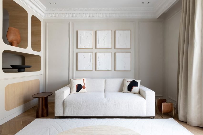 A view of a living room containing a white sofa in a historic Parisian apartment.