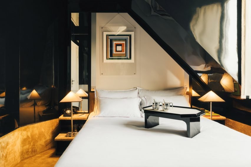 Interior view of a hotel bedroom showcasing black lacquer panels that create a spacious feeling.