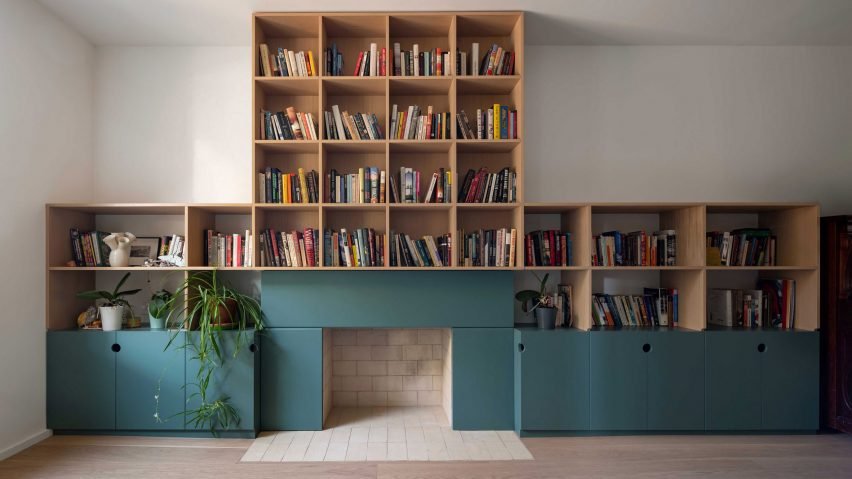 Teal fireplace with oak bookshelves above