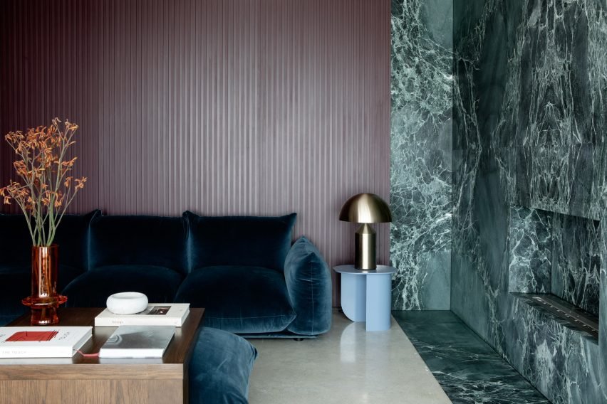 A living space showcasing a green marble feature wall designed with swirly book-matched marble.