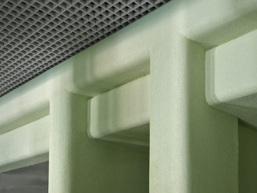 Filleted stucco surfaces contrast an aluminium open-cell grid ceiling