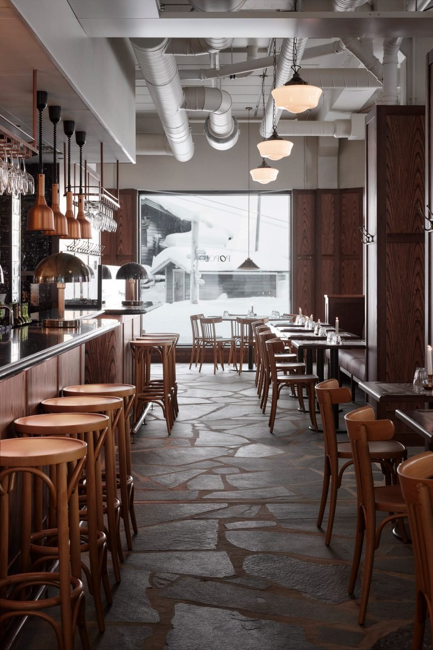 A bar area with leather seating and copper lamps.