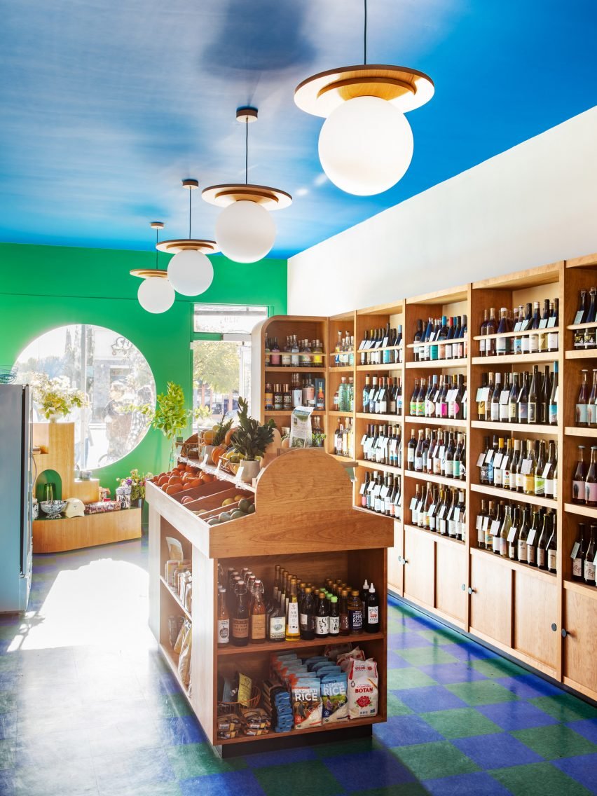 The interior of Wine and Eggs grocery store, featuring custom lamps resembling sunny-side-up eggs, enhances its playful Parisian cafe ambiance.