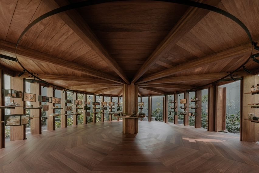 The pavilion features a tongue-and-groove ceiling supported by structural beams emanating from a central pillar.