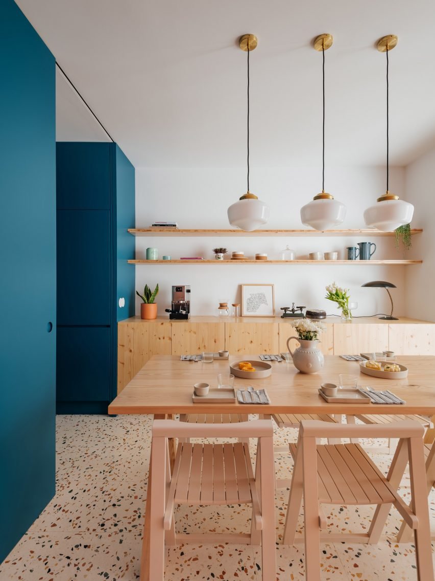 The dining area is revealed with an oak table and pendant lights, integrated with the kitchen layout.