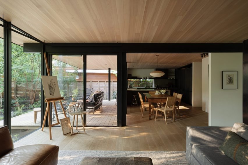 Living room with wooden floor and ceiling, looking towards the dining room