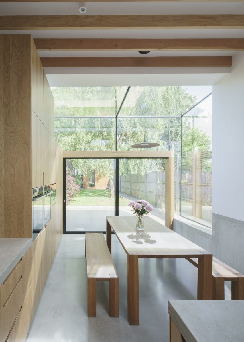 A glass extension in Hertfordshire, UK, by DHaus, opens up a compressed kitchen to the garden with ample lighting.