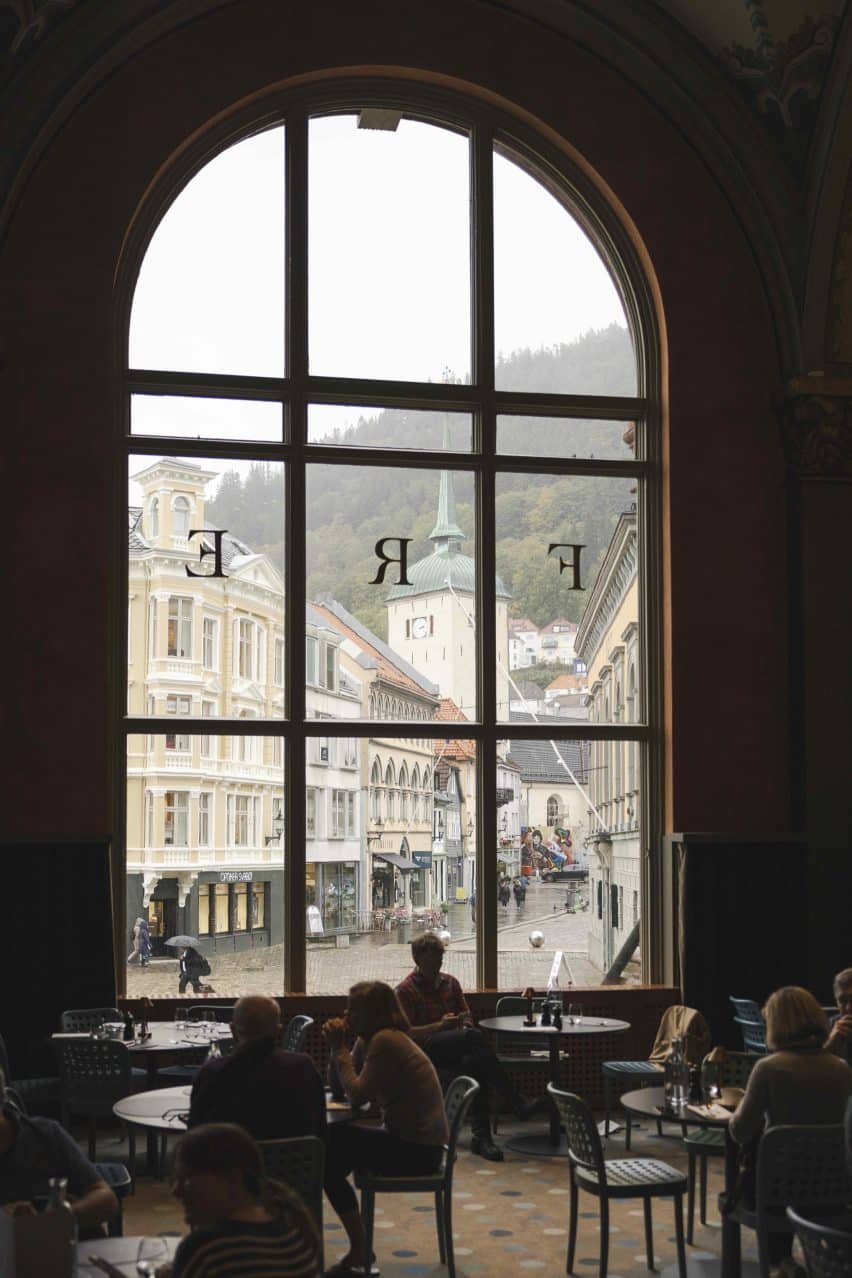 Restaurant interior lit by giant arched window