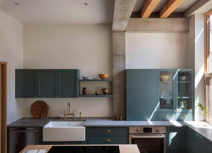 Monroe Street House in Brooklyn, USA, by TBo, showcases a bright kitchen with a ceiling-high window and outdoor deck access.