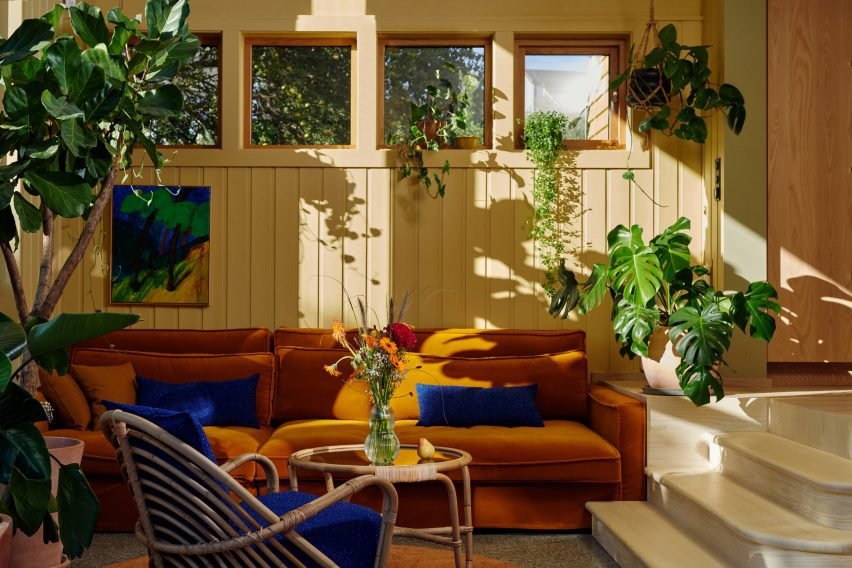 Conservatory in Yellow House in the Apple Garden with a terrazzo floor and ochre sofa.