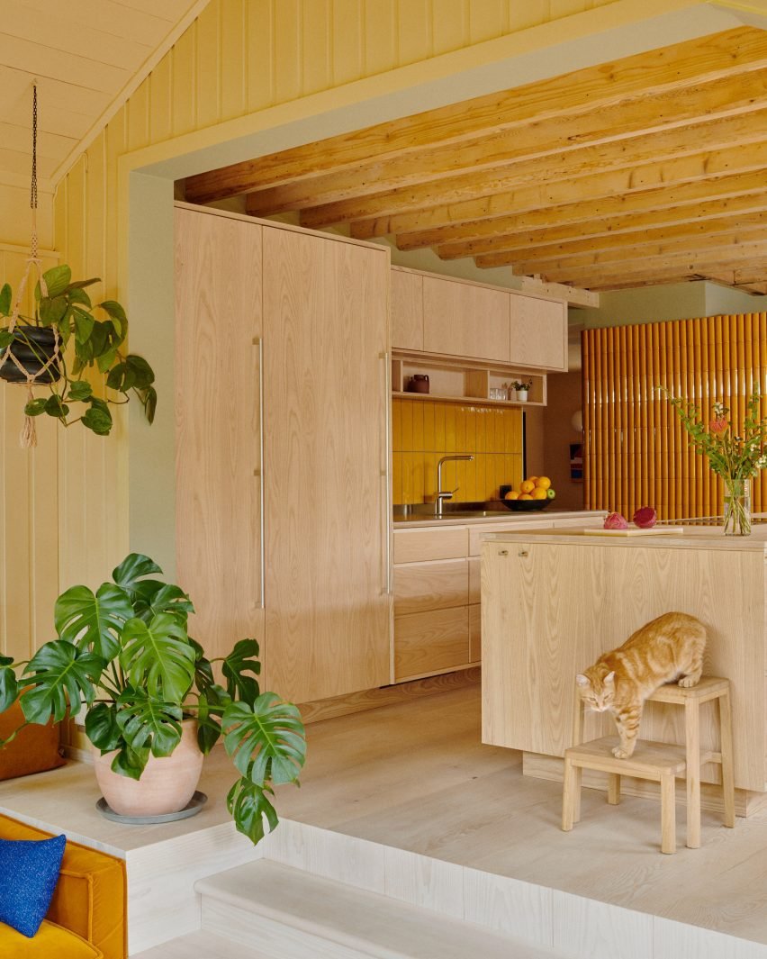 Kitchen with ash cabinets and yellow tile splashback.