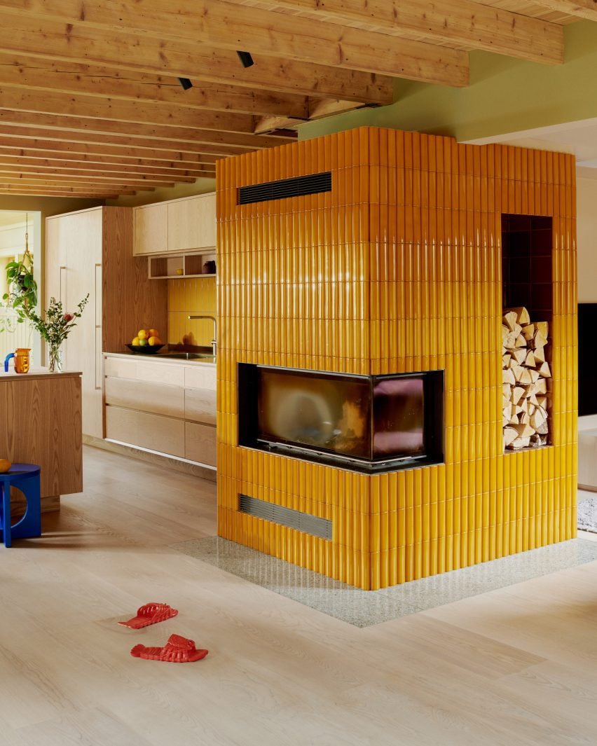 Fireplace with yellow tiles by Familien Kvistad.