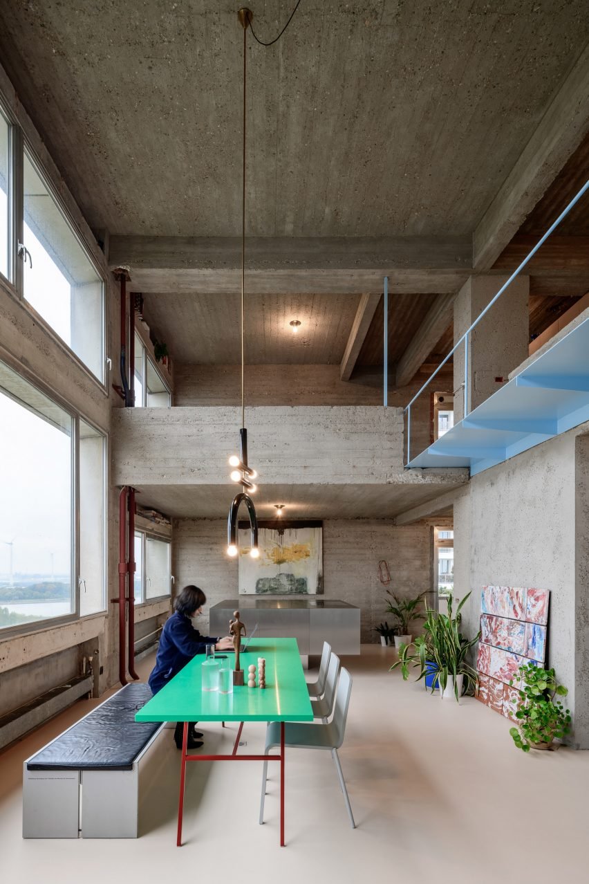 Monolithic travertine table located in the large living and dining room at Barwon Heads House, surrounded by black chairs.