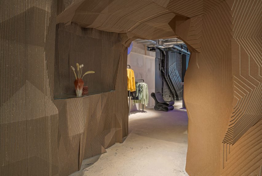 Cardboard cave next to the displayed car, partially hidden by a light chain curtain.