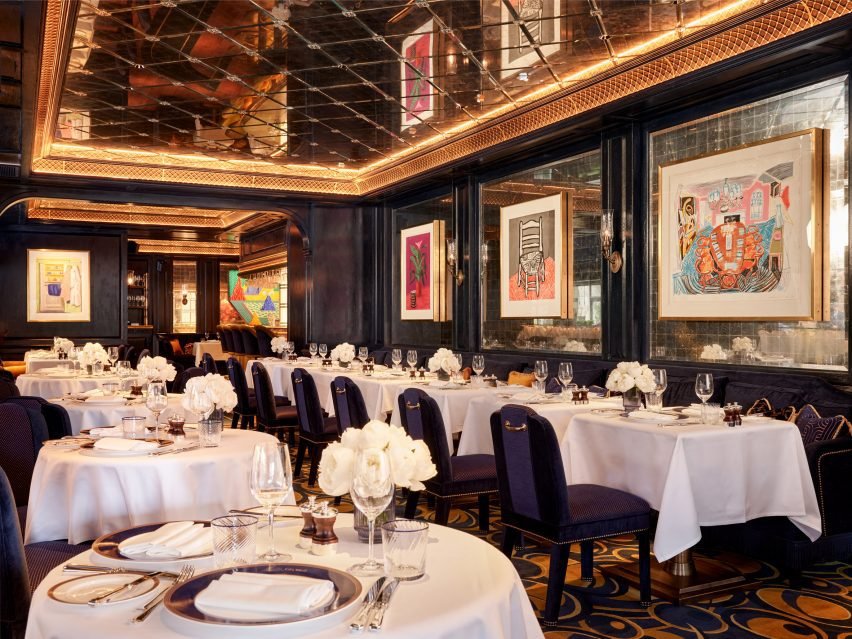 Paintings hang in mirror-tiled panels of the dining room, under a mirrored ceiling recess