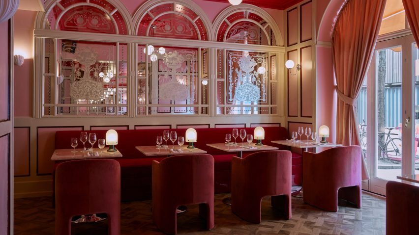 A vibrant interior of the Donna restaurant featuring bold red-and-white checkerboard tiles and colorful upholstered banquettes.