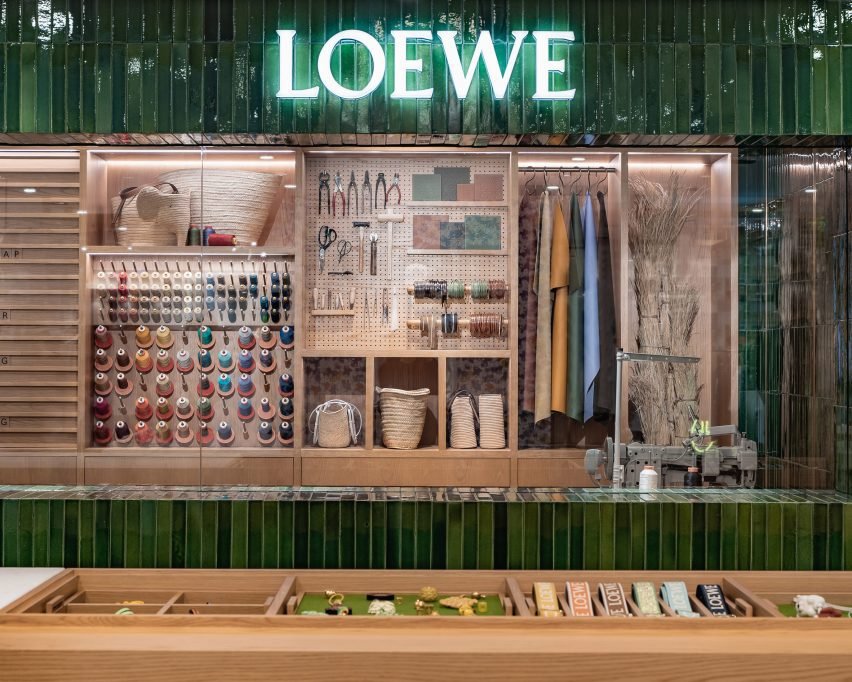 View of the repair room through a window, showcasing various leather swatches and tools.