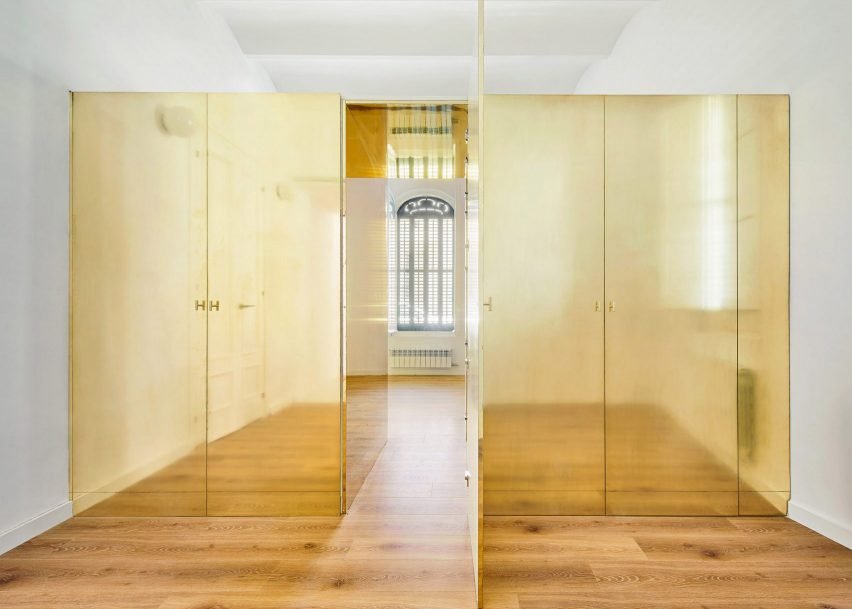 A yellow wardrobe in an apartment renovation designed by Pedro Varela & Renata Pinho in Portugal, showcasing unique circular handles and a playful design.