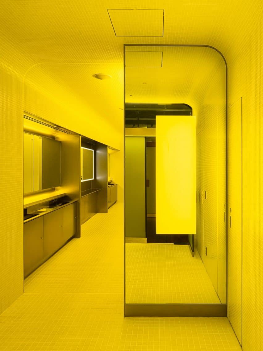 Stainless-steel sinks provide a modern contrast against the white tiles.