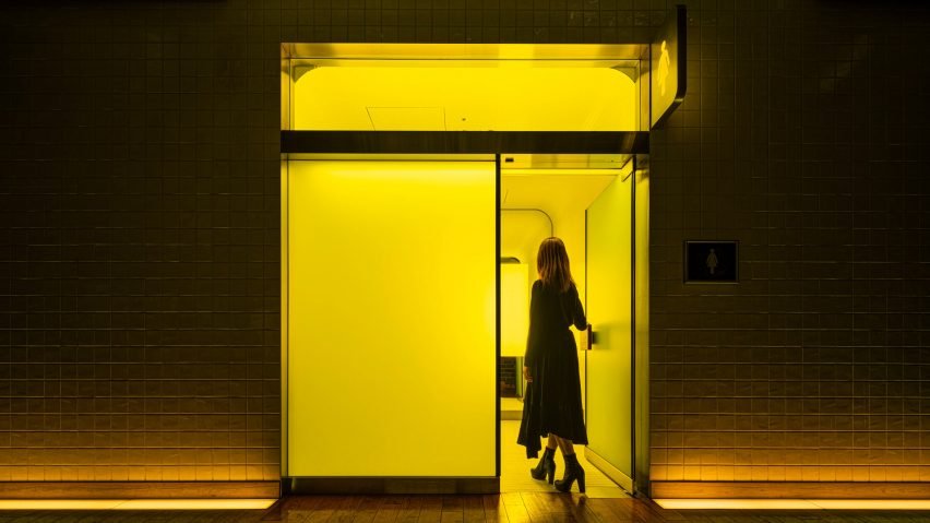 The bright green and yellow light marking the bathrooms creates a vivid atmosphere.