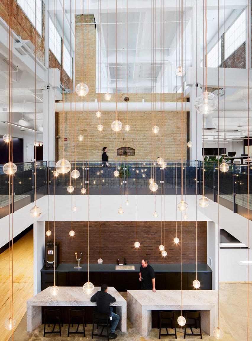 Atrium filled with glass globe lights suspended on individual wires.