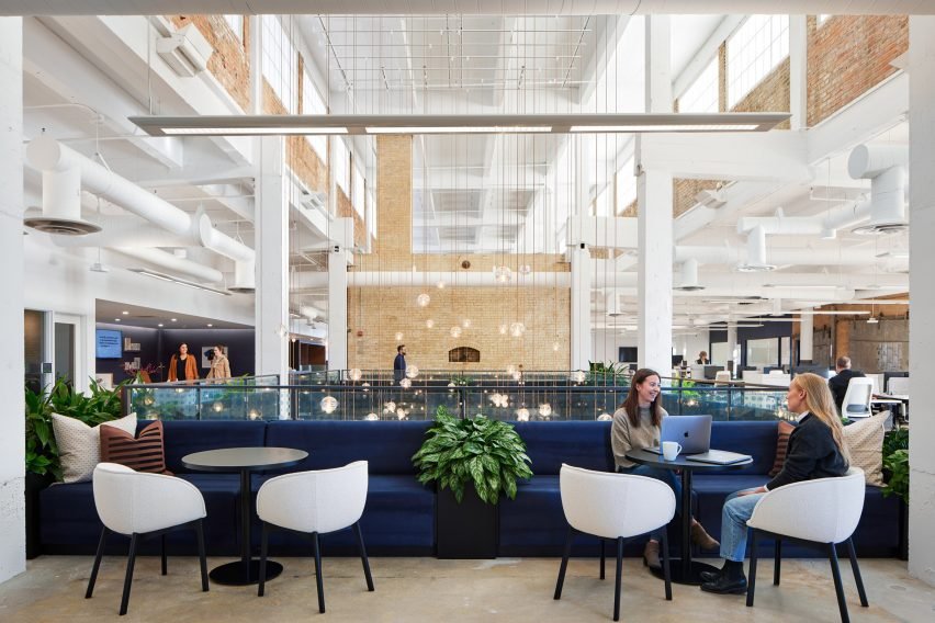 Dark blue lounge seating in front of atrium with abundant natural light.