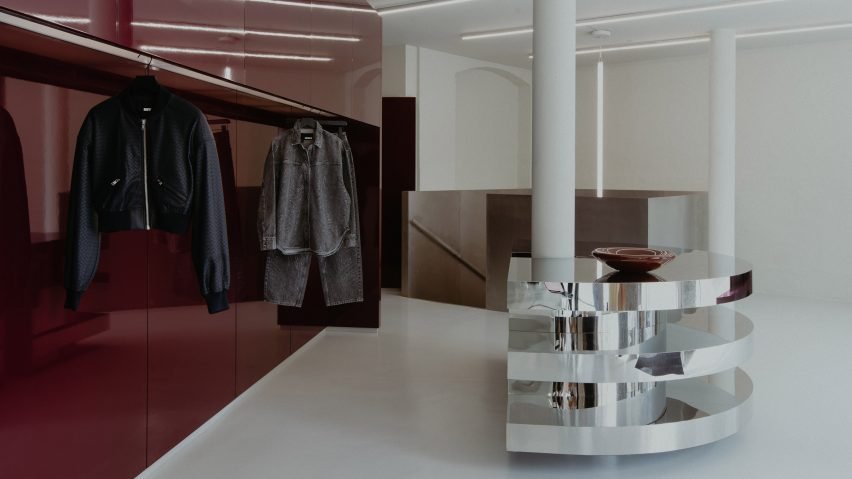 Shiny silver curtains and a lacquered burgundy stage feature inside the flagship store for the Danish womenswear label Rotate.