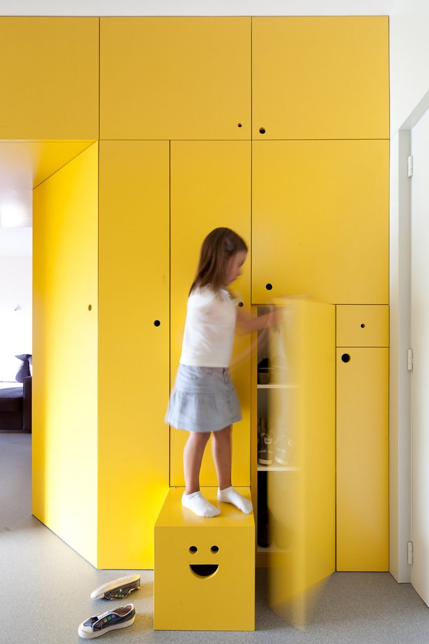 Wardrobe designs that are part of the Wood Ribbon apartment in Paris, creating distinct zones while providing essential storage.